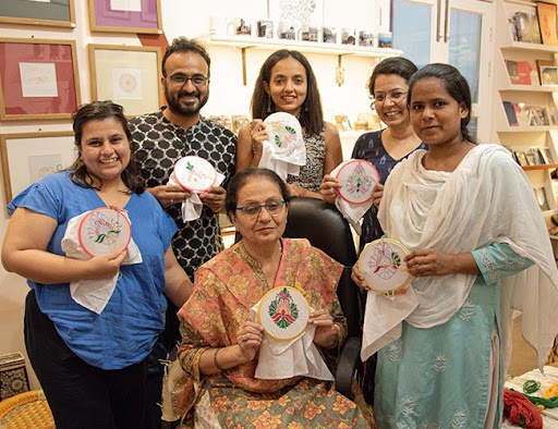 Group displaying embroidery craftwork image showing on the Sanatkada About Us page
